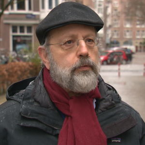 Jonathan Zeitlin är professor vid Amsterdams universitet. Professor Jonathan Zeitlin. Han är en man i medelåldern. Bilden är tagen utomhus. Det är fortfarande tidig vår i Amsterdam och det regnar.
