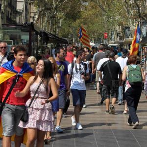 Jalankulkijoita ja lippuja Barcelonan Ramblalla.