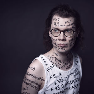PItkähiuksisen radiotoimittaja Jani Tanskasen kasvoille ja iholle sekä hihattomaan paitaan on kirjattu psykiatristen diagnoosien nimiä ja koodeja tautiluokituksesta ICD-10.