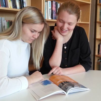 Anna Sjöblom och Mathilda Törnqvist läser i en lärobok
