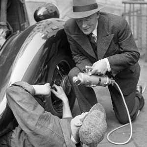 Alexis af Enehjelm haastattelemassa autoa korjaavaa miestä 1930-luvulla. Arkistokuva.