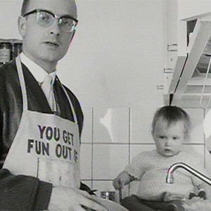 Toimittaja Pekka Holopainen tiskaa, tiskipöydällä istuu pieni tytär (1966).
