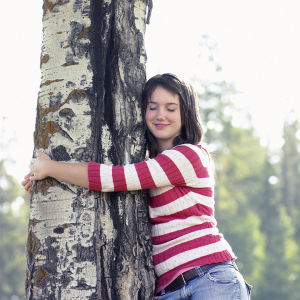 Nainen halaa puuta