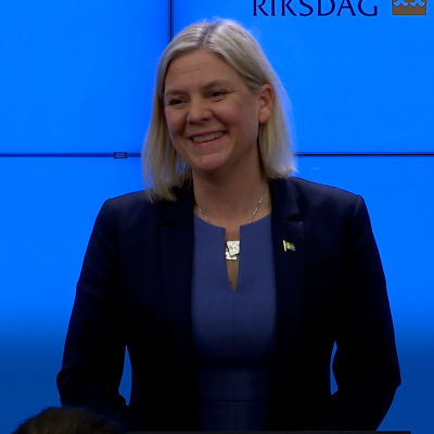 Magdalena Andersson ler mot kameran udner en presskonferens.