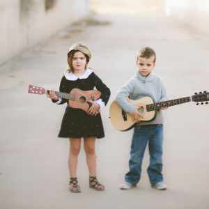 tyttö ja poika soittavat kitaraa