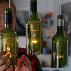 Kuvassa viinipulloista tehtyjä valaisimia