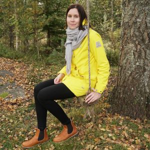 Kati Parkkinen istuu keinussa syksyisessä maisemassa
