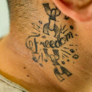 Kaulaan tatuoitu mustalla sana freedom.