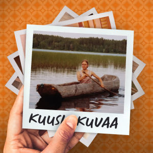 Nuori nainen meloo puunrungosta koverretulla kanootilla järvellä, taustalla sekametsäinen rinne.