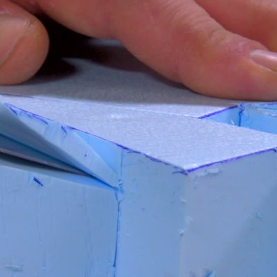 Polystyrenet formas med en mattkniv.