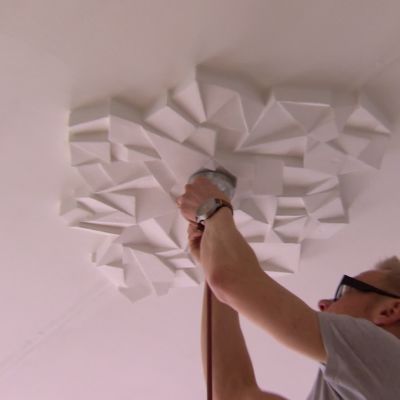 Jim installerar lampan under takrosetten.