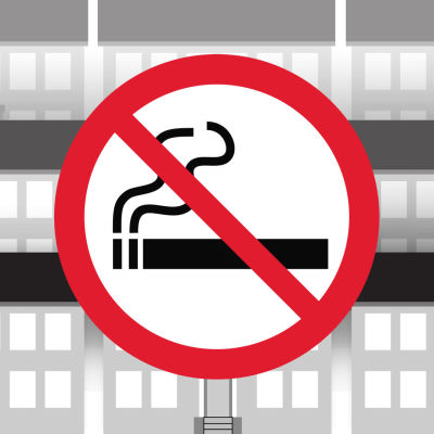 Grafiikka: tupakointi kielletty -merkki, taustalla kerrostaloja.