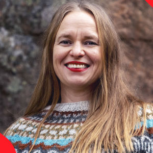 Kirjailija Satu Rämö kallion edessä villapaita päällään.