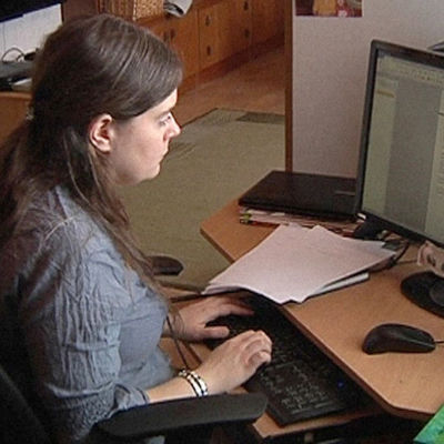 Kirjailija Minttu Vettenterä istuu tietokoneella.