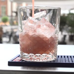 En alkoholfri, rosa drink hälls i ett glas. 