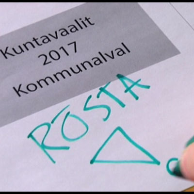 En text som säger Kommunalval 2017 och en hand som håller i en penna och skriver: Rösta!