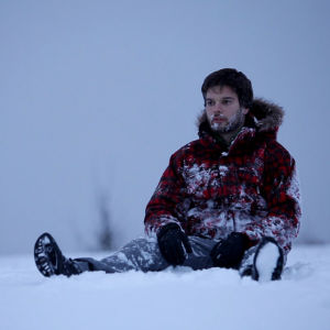 näyttelijä Kasimir Baltzar istuu lumessa