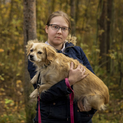 Oululainen Miia Seppälä pitää koiraansa sylissä