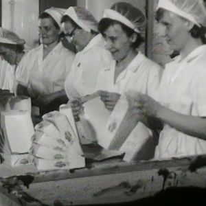 Naiset lajittelevat mämmirasioita tehtaalla.