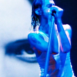 Dave Gahan lavalla, takana iso lähikuva hänestä. Kuva Depeche Moden Devotional-kiertueelta 1993.