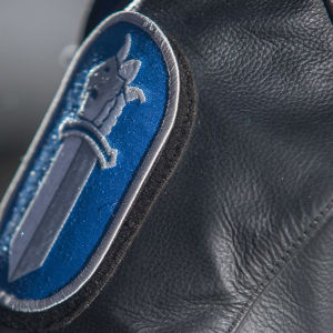 Poliisin hihamerkki nahkatakissa.