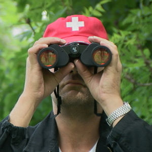 Roman Schatz katsoo kiikareilla kameraan päin