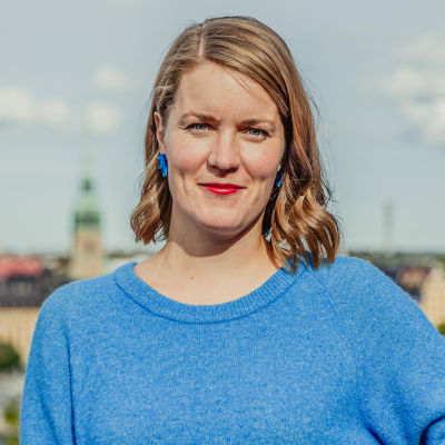 En bild av Marianne SUndholm med en vy över Stockholm i bakgrunden.