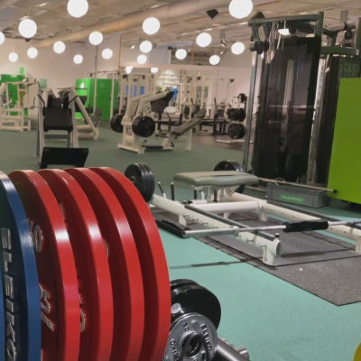 Ett tomt gym. I förgunden vikter, i bakgrunden maskiner av olika slag.