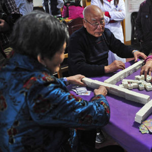 Vanhukset pelaavat mahjongia yksityisessä hoitokodissa.