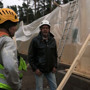 Kaksi miestä keskustelevat rakennustyömaalla