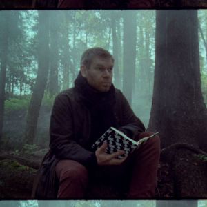 Kriitikko Kalle Kinnunen istuu sumuisessa metsässä muistikirja käsissään.