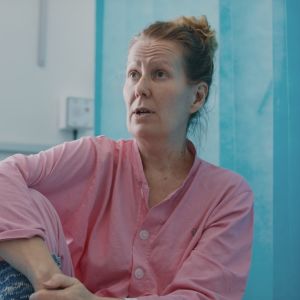 Ursula Vasama koronaosastolla, istuu sairaala vuoteella