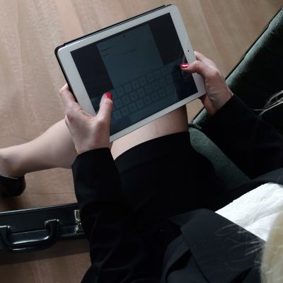 Nainen käyttää tablet-tietokonetta.