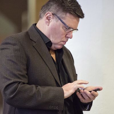 Jari Aarnio näppäilee puhelintaan.