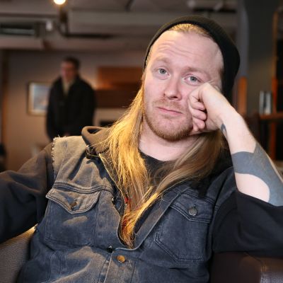 Mies katsoo pitkästyneenä kameraan.