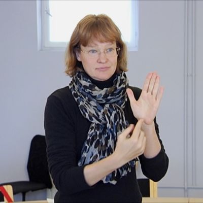 Karin Hoyer viittoo.