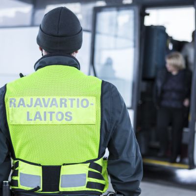 Rajavartija tarkkailee venäläisiä turisteja.
