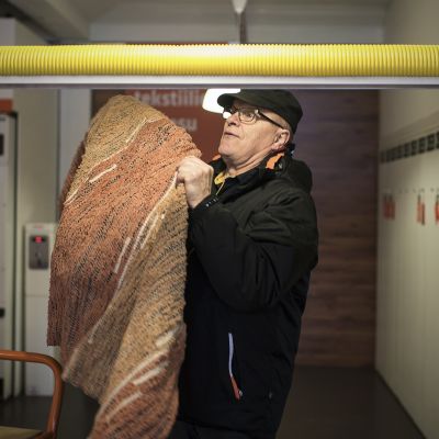 Reijo Meriläinen ripustaa mattoja kuivumaan.