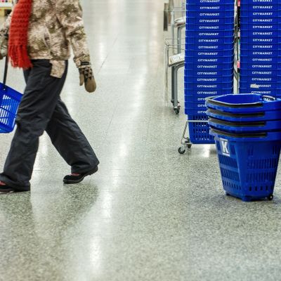Henkilö ostoskorien luona.