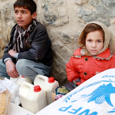 Lapset istuvat ruokasäkkien vieressä Kabulissa.