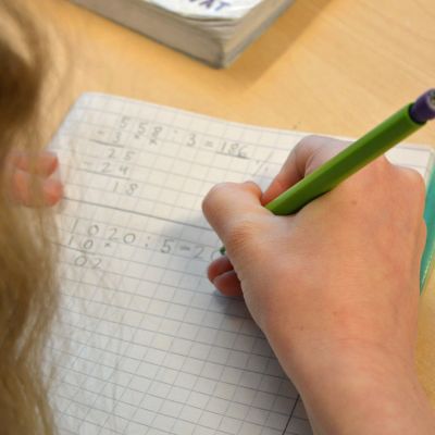 Tyttö laskee matematiikan tehtävää.