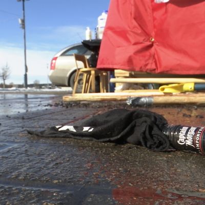 Rikkinäinen pullo teltan edustalla Oulun torilla.