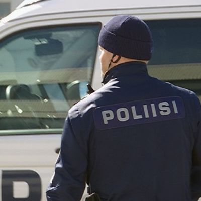 Lapin poliisin vanhempi konstaapeli Janne Vaarala selin kameraan poliisiauton edessä.