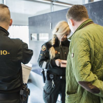 Rajavartijat tarkastavat miehen asiakirjoja Nuijamaalla