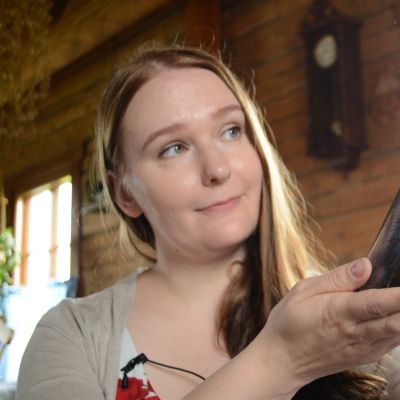 Lasitaiteilija ja muotoilija Sini Majuri, kädessään uusimman Vuori-sarjan lasitaideteos.