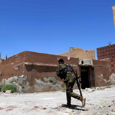 SDF-joukkojen taistelija ryntää kadun yli Raqqan länsiosassa, Daryan kaupunginosassa