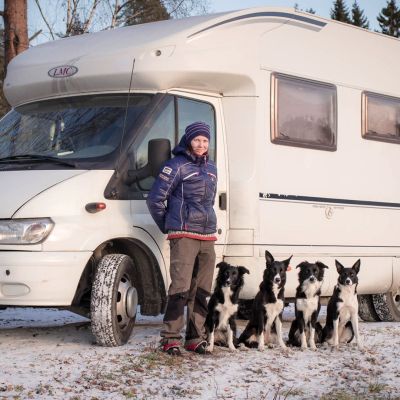 Tanja koirineen matkailuauton edessä.