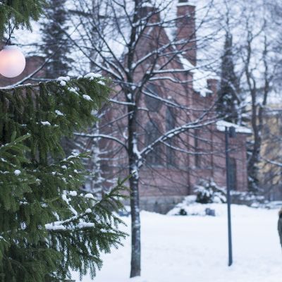 Iso joulukuusi ja kirkkopuiston kirkko taustalla