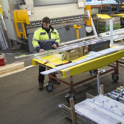 Jääkiekkokaukalon osien kasaamista Vepe Oy:n tehdashallissa Tuusulassa. Työnjohtoharjoittelija Henri Savolainen kasaamistöissä.