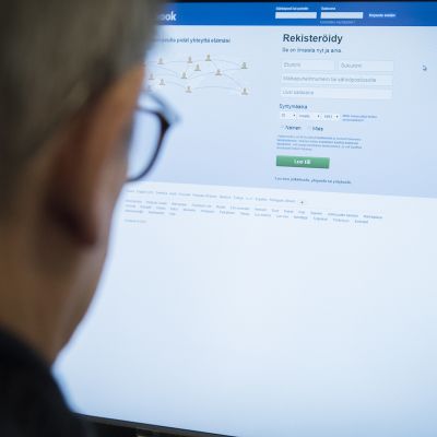 Mies tietokoneen ääressä kirjautumassa Facebookiin.